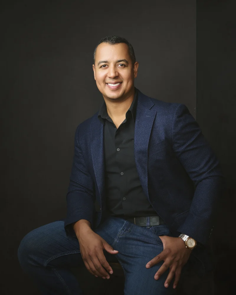 Phoenix professional in a navy blazer over a black shirt with no tie, a modern approachable headshot look photographed in Gilbert Arizona