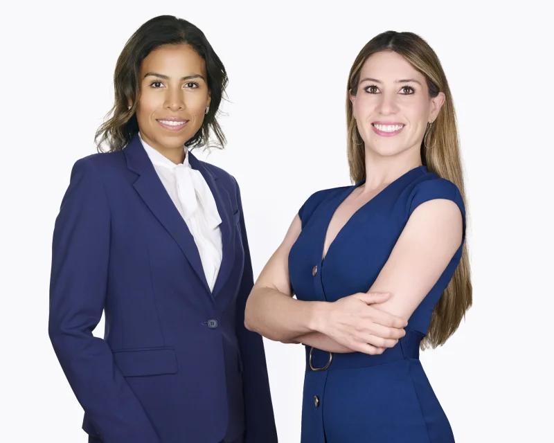 Two women in navy business attire standing side by side against a white background for professional headshots in Phoenix, Arizona