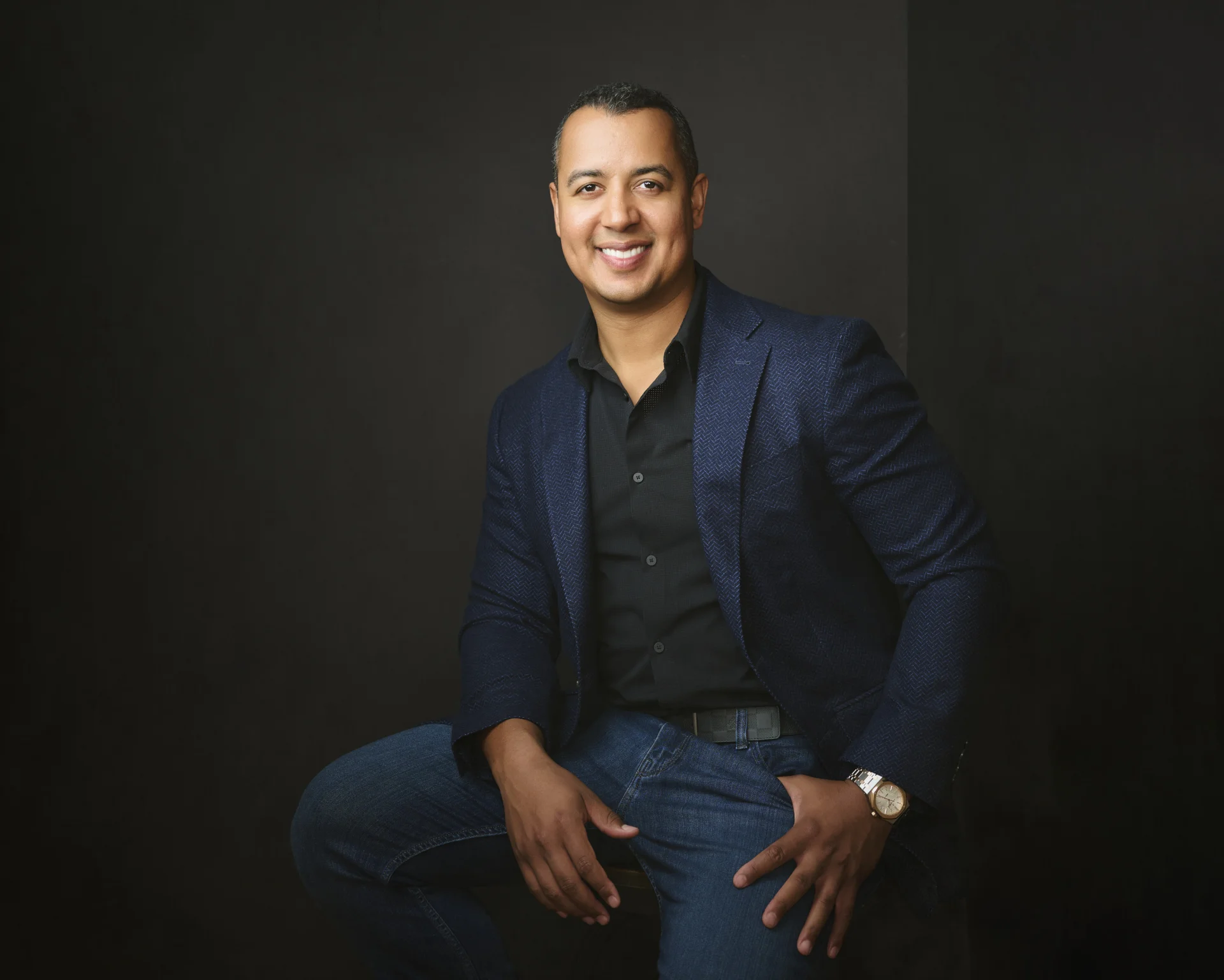 John Meade, cinematic portrait in navy blazer against dark backdrop by Marie Feutrier