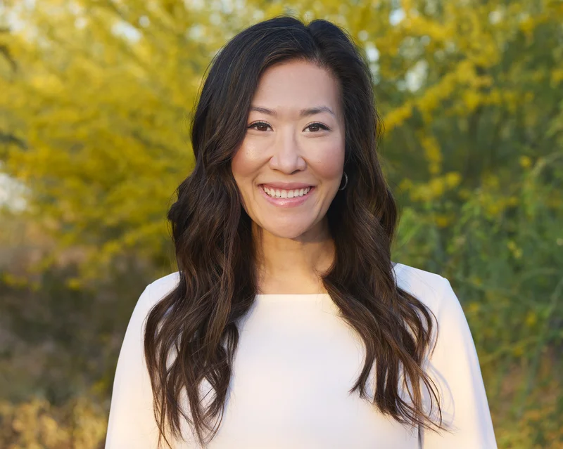Outdoor professional headshot of dentist with Arizona greenery background Phoenix