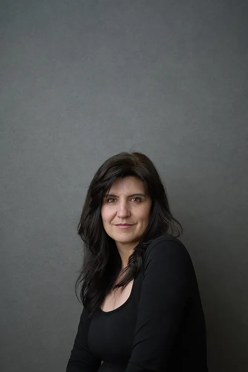 Marie Feutrier professional headshot photographer holding camera in studio