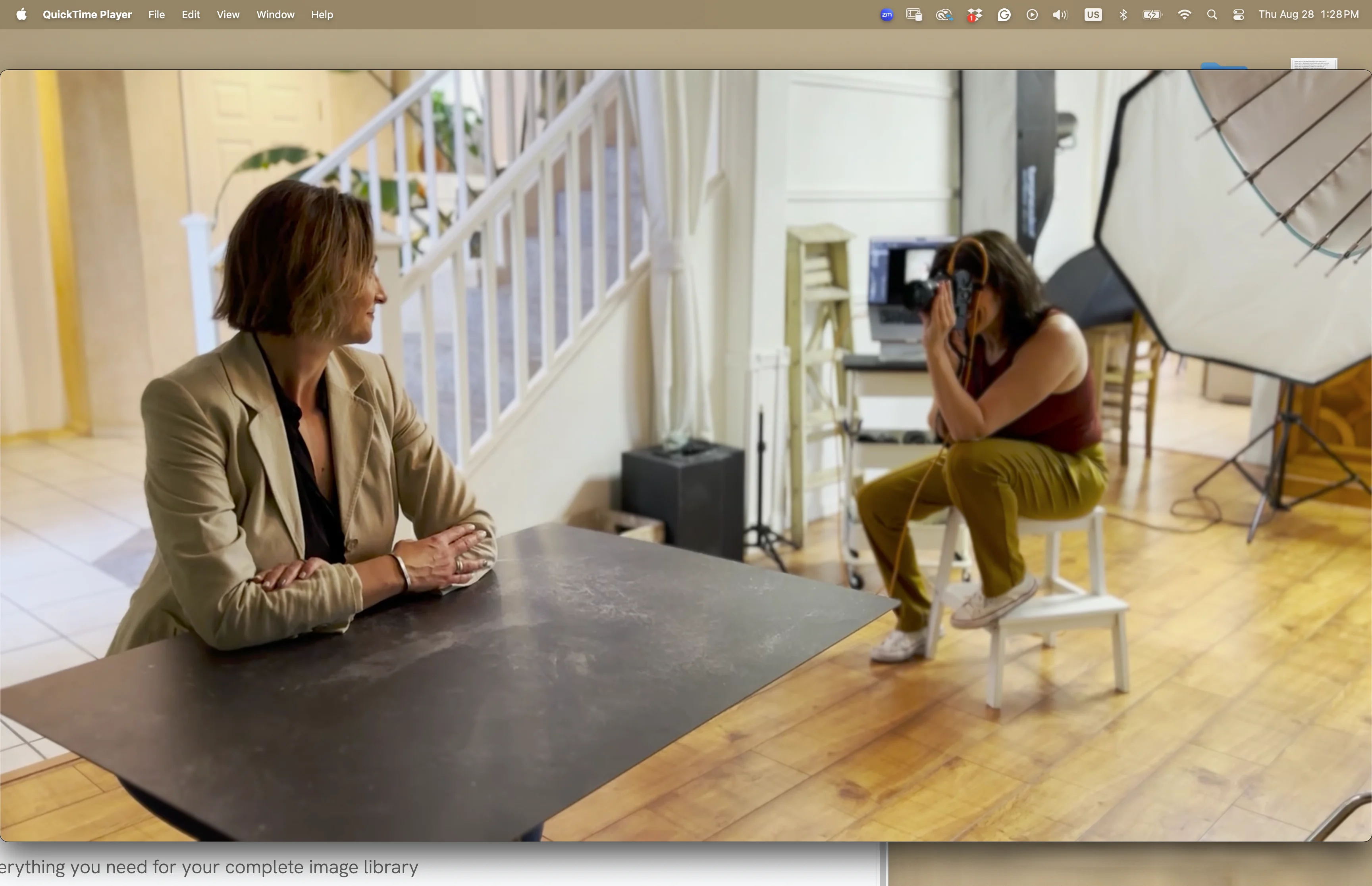 Photographer directing client during headshot session on gray backdrop with professional studio lighting
